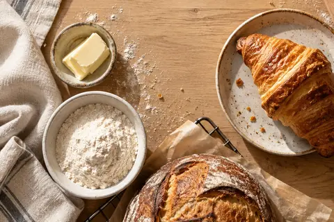 Generated bakery still life with bread, a golden croissant and cream linen.